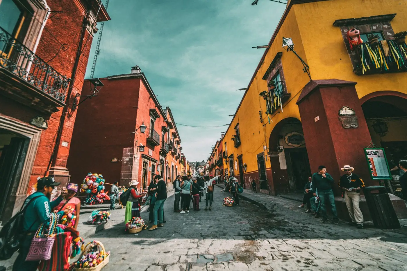 Calle colonial de colores con personas caminando